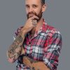 Bearded male with tattoo on his arm isolated on grey background.